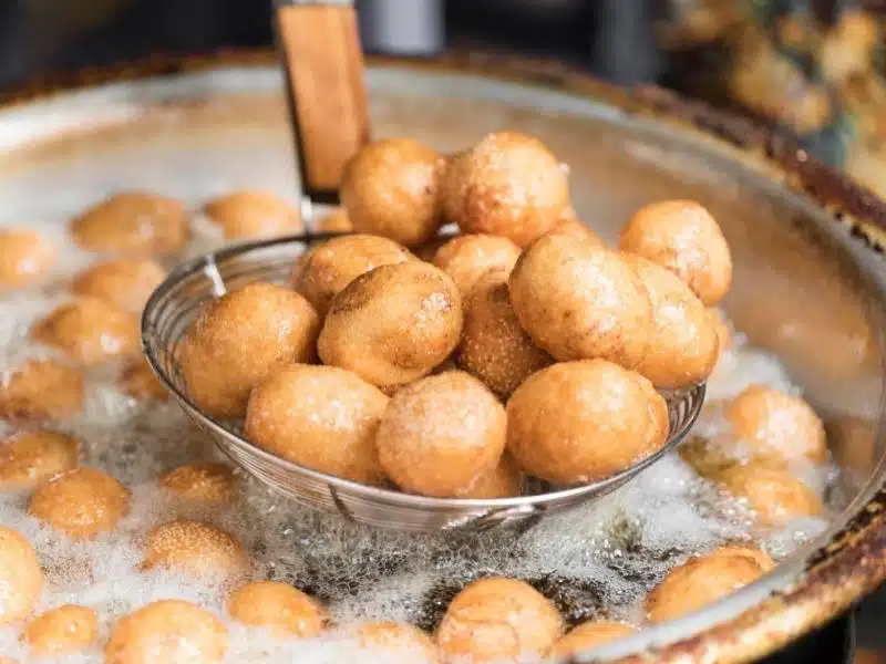 Banh Ran or deep fried glutinous rice balls being fried in a vat of oil in northern vietnam