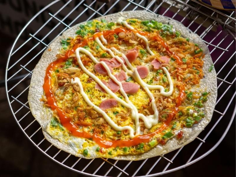 A banh trang nuong, also known as Vietnamese pizza, on a metal rack