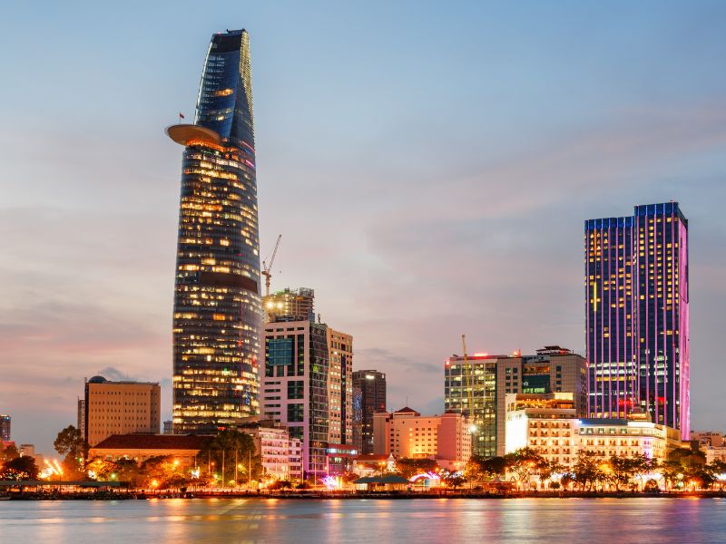 Skyline of Ho Chi Minh City by the river, with towering Bitexco Financial Tower on the left