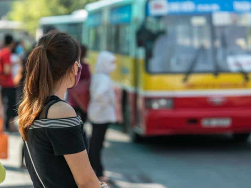 A woman seen from behind waiting for a bus in Vietnam