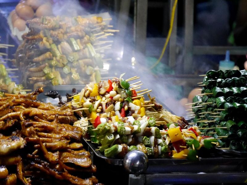 Some grilled veggie and meat sticks in a Vietnamese market