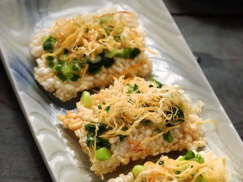 Rectangular pieces of com chay, a burned rice snack in Vietnam, on a white plate