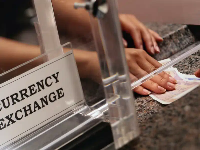 A hand passing some bills at a currency exchange booth in Vietnam