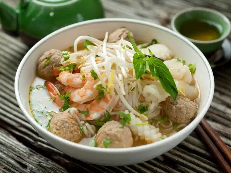 A bowl of the southern Vietnam style of pho loaded with bean sprouts, beat balls, and more